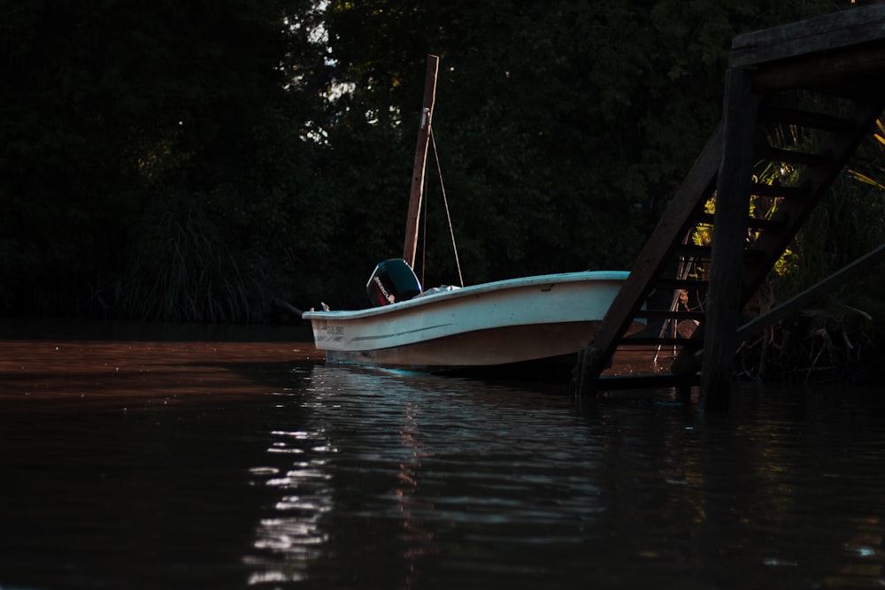 white boat docked in front of wooden stair during daytime