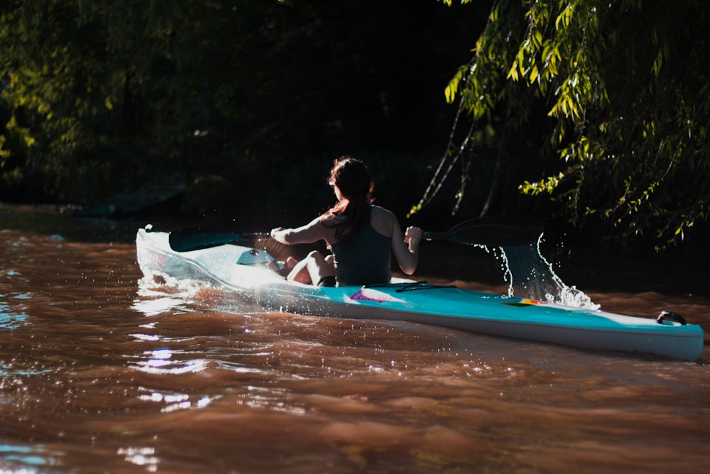 femme pagayant à travers la rivière