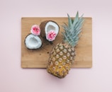 pineapple fruit beside coconut on top of chopping board