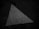 A weathered, white triangular road marking is visible on a dark asphalt surface. The texture shows signs of wear and has a slightly rough appearance, suggesting age and exposure to the elements.
