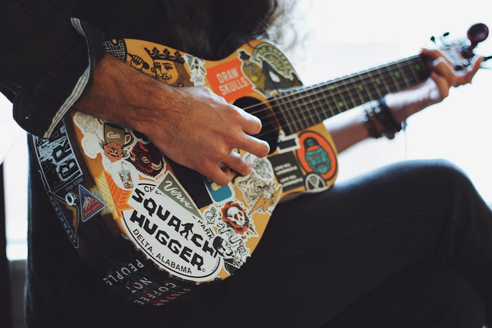 Persona tocando la guitarra acústica