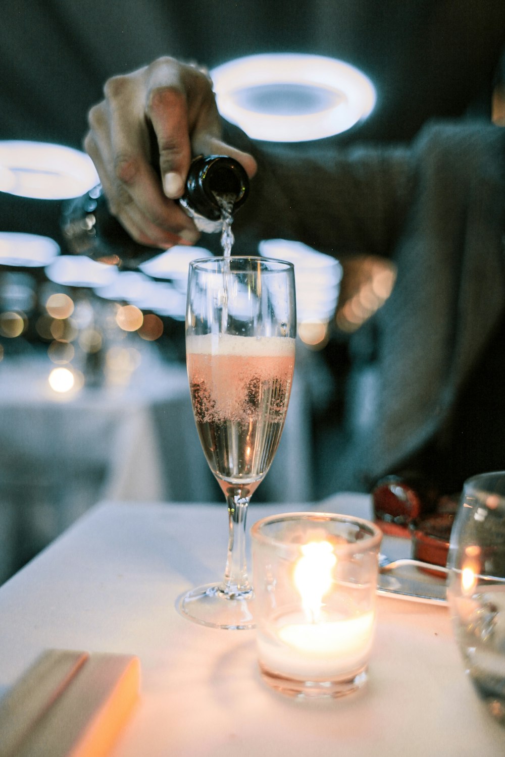 personne mettant du champagne dans un verre à champagne