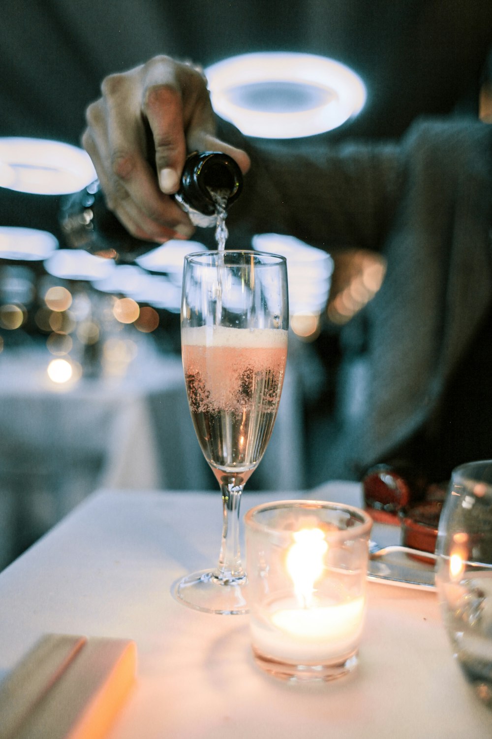 person putting champagne in champagne glass