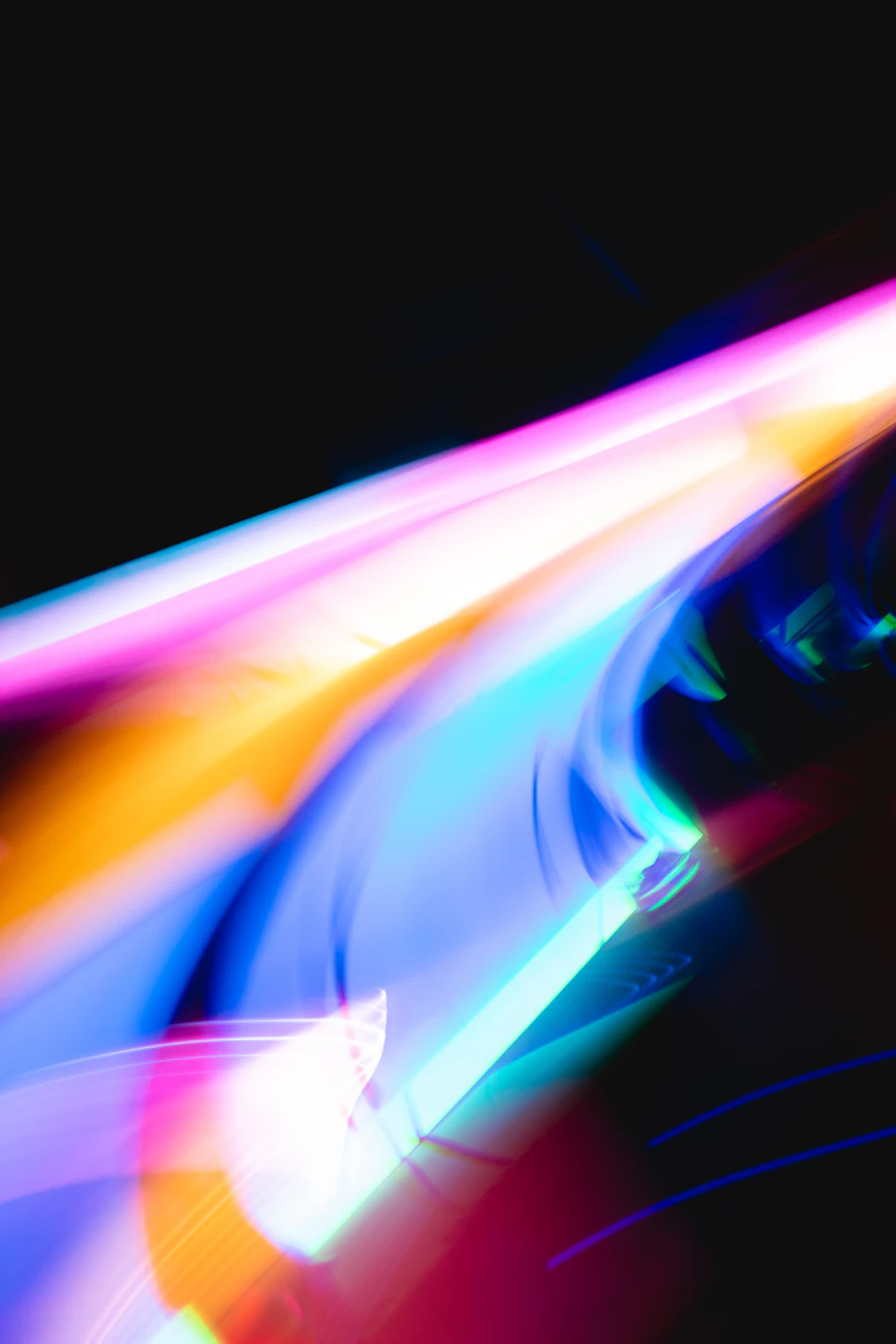 Abstract long-exposure light trails in blue, pink and orange