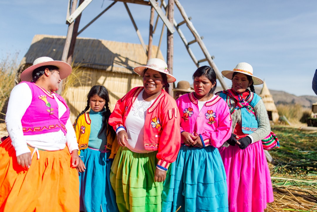 group of women wearing pleated dresses near barn, Peruvian Women