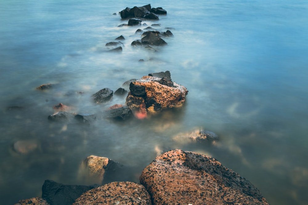 brown rocks in blue water during daytime