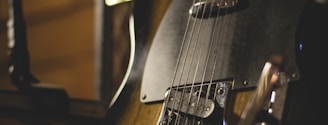 shallow focus photo of black and brown electric guitar
