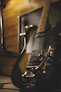 Close-up shot of a guitar resting on stage with soft, warm lighting.