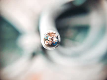selective focus photography of white coated wire