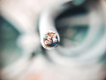 selective focus photography of white coated wire