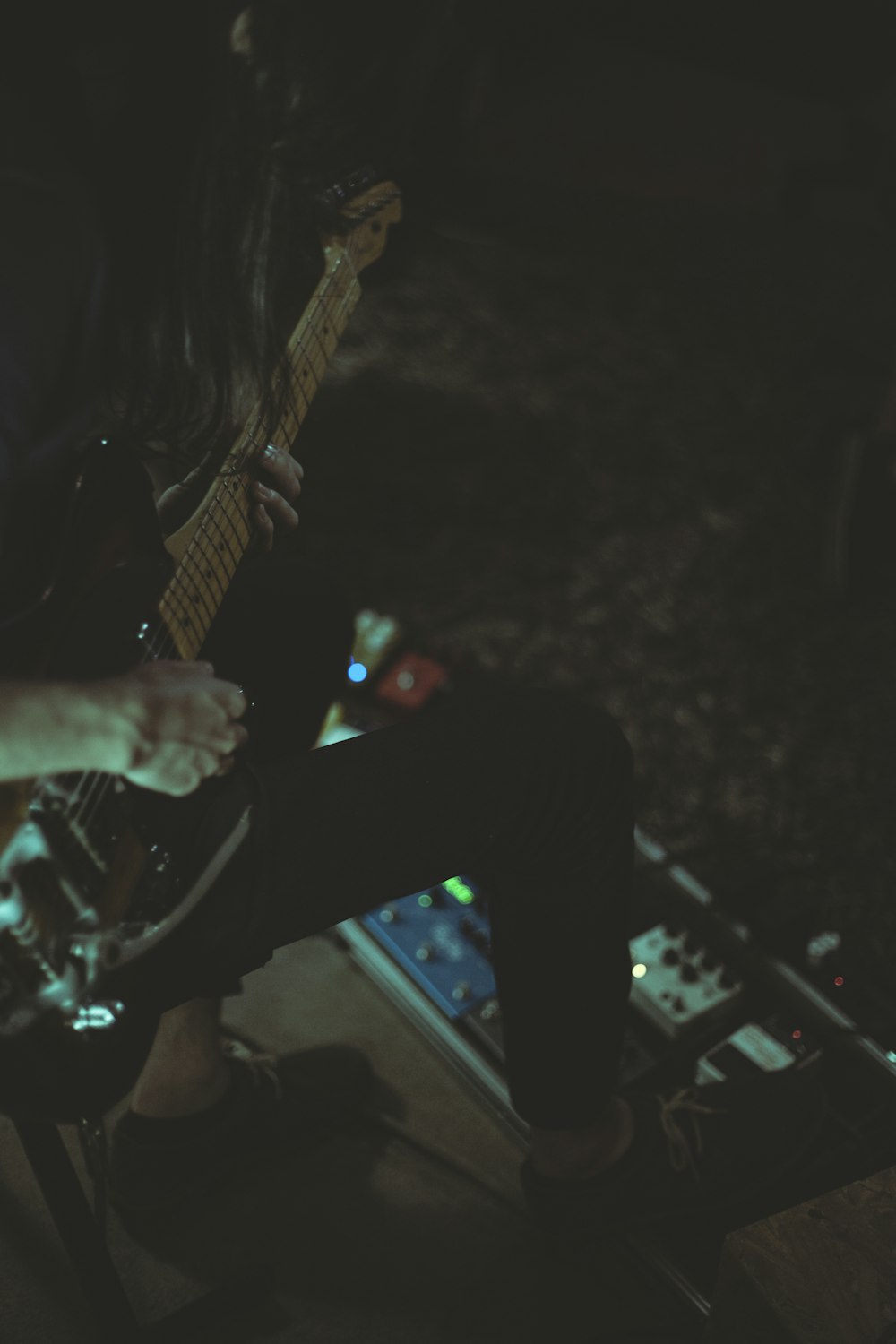 a person playing a guitar in a dark room