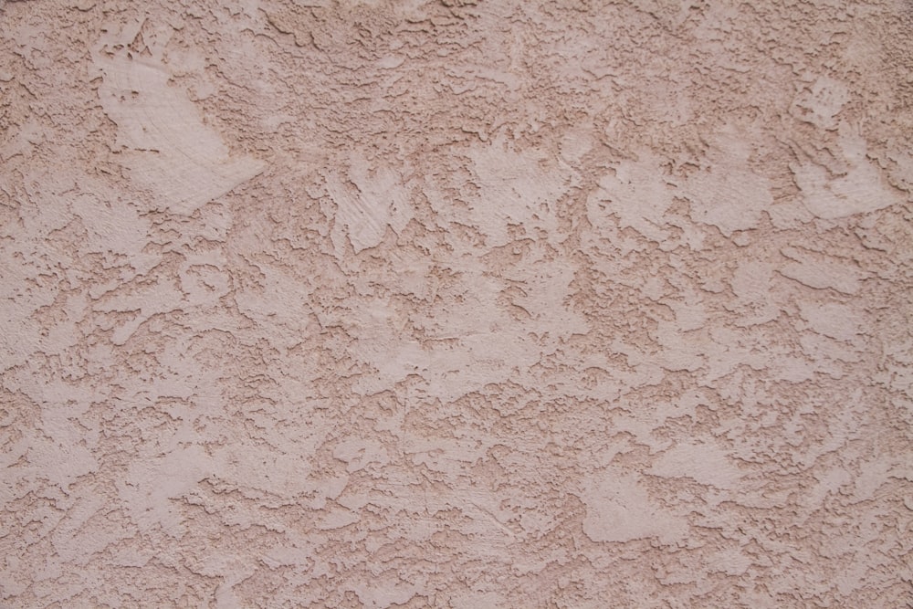 a close up of a stucco wall with a red fire hydrant