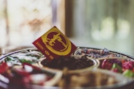 Artfully packaged RaabhiFoods dry fruits set against a backdrop of natural wood and greenery.