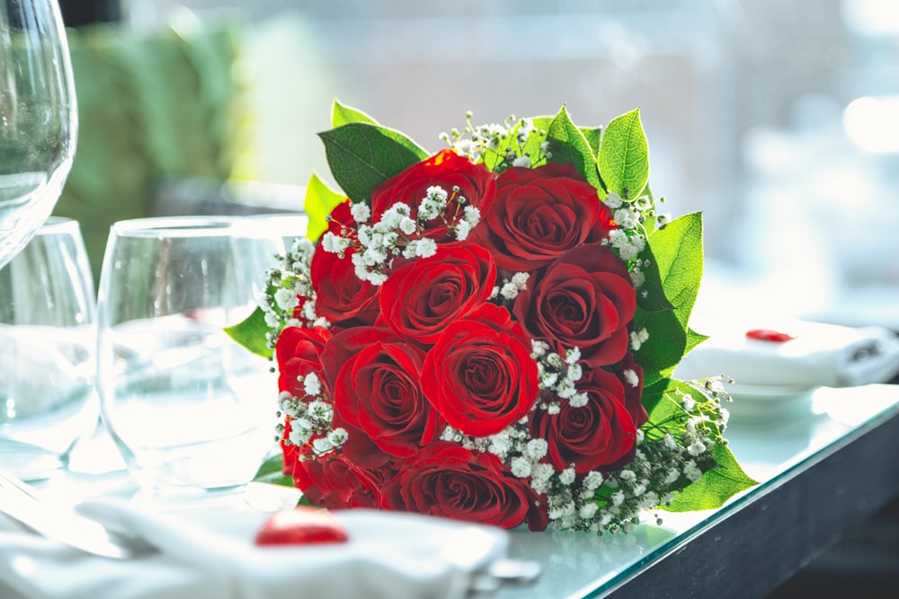 rose bouquet on table beside empty drinking glasses