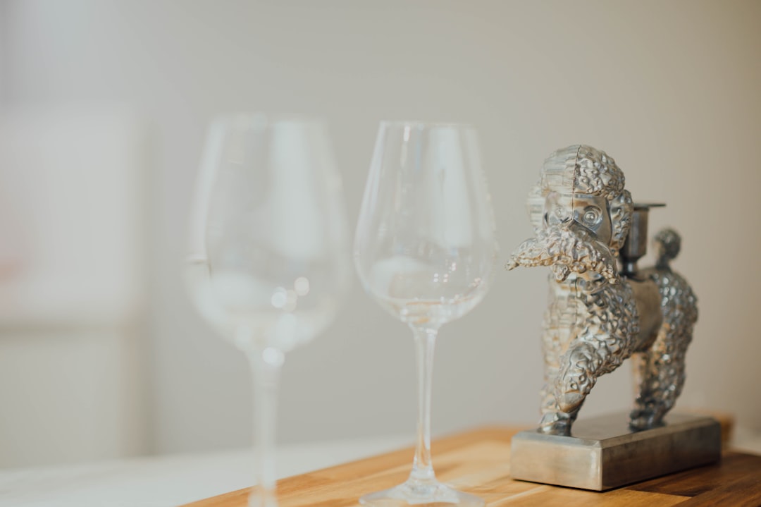 two clear footed wine glasses on brown wooden table