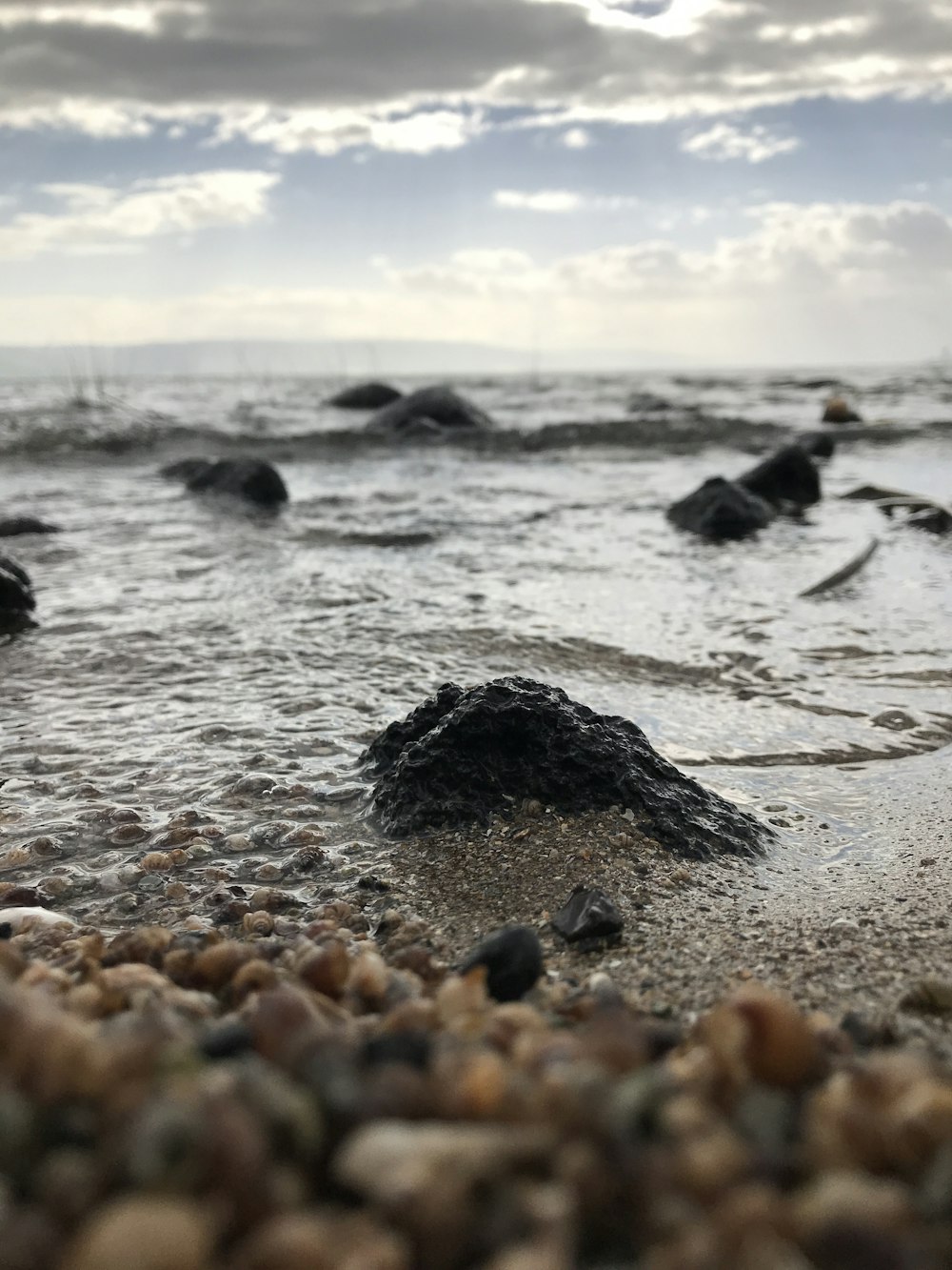 waves bashing shore under white clouds