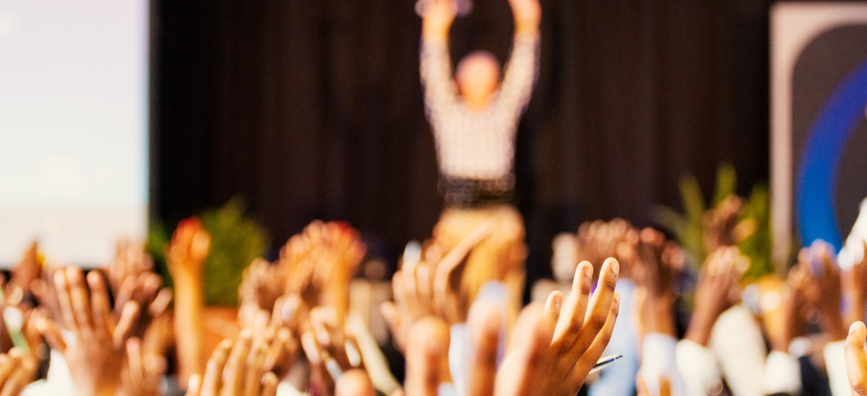 people raising hands with bokeh lights