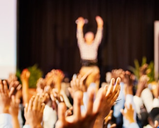 people raising hands with bokeh lights