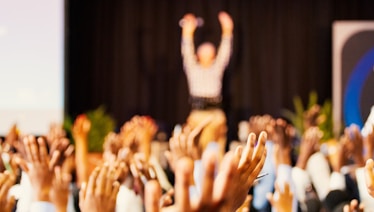 people raising hands with bokeh lights