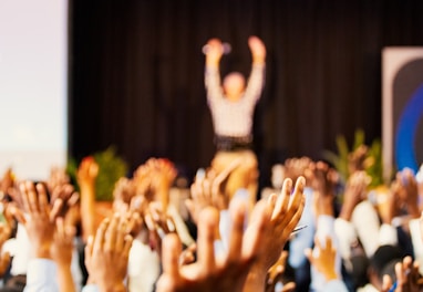 people raising hands with bokeh lights