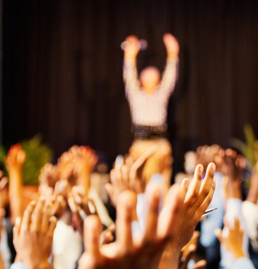 people raising hands with bokeh lights