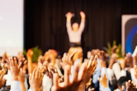 people raising hands with bokeh lights