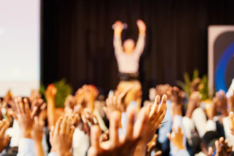 people raising hands with bokeh lights