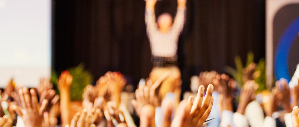 people raising hands with bokeh lights