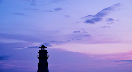 A serene lighthouse silhouette against a twilight sky, symbolizing guidance and dreams.