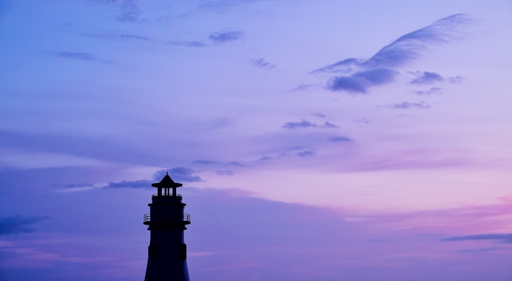 silhouette of lighthouse under purple sky