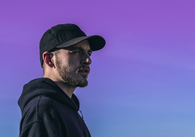 man wearing black cap cap google meet background