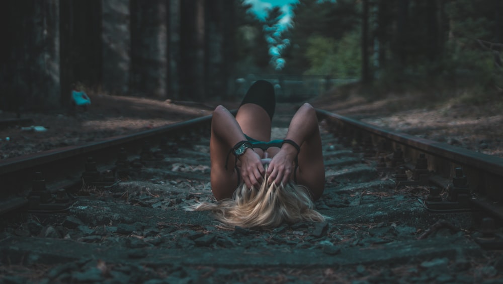 woman lying on train rails