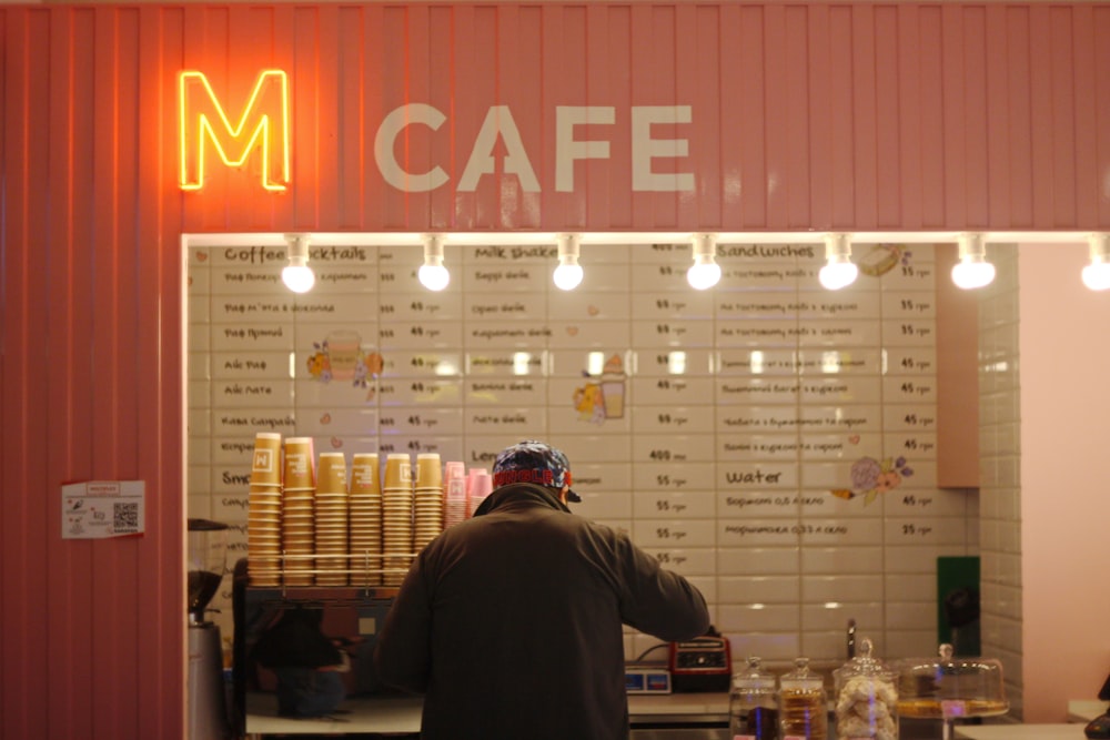 man standing in front of M Cafe store