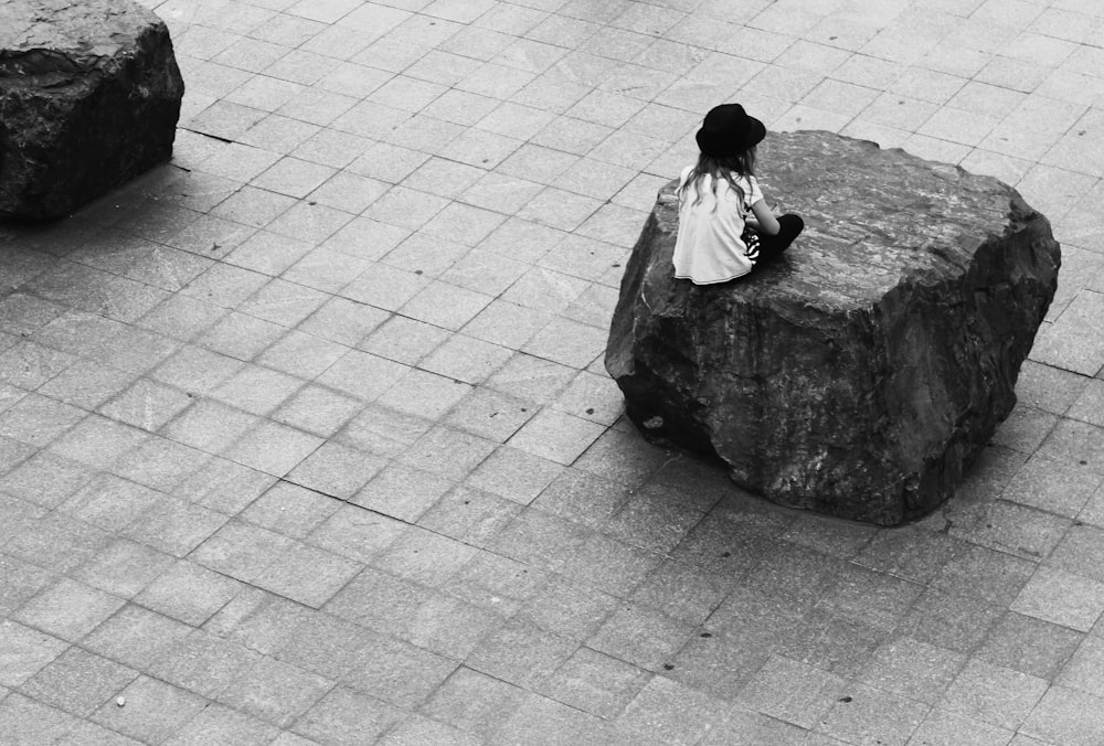 woman sitting on rock