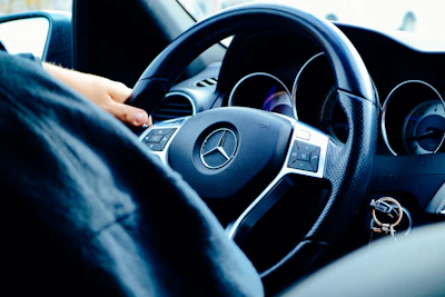 Close-up of hands shaking over a car purchase agreement with a German car in the background.