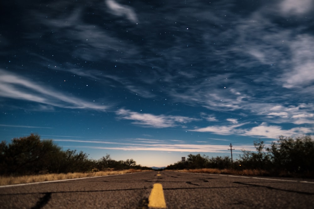 Carretera de asfalto gris bajo un cielo azul claro