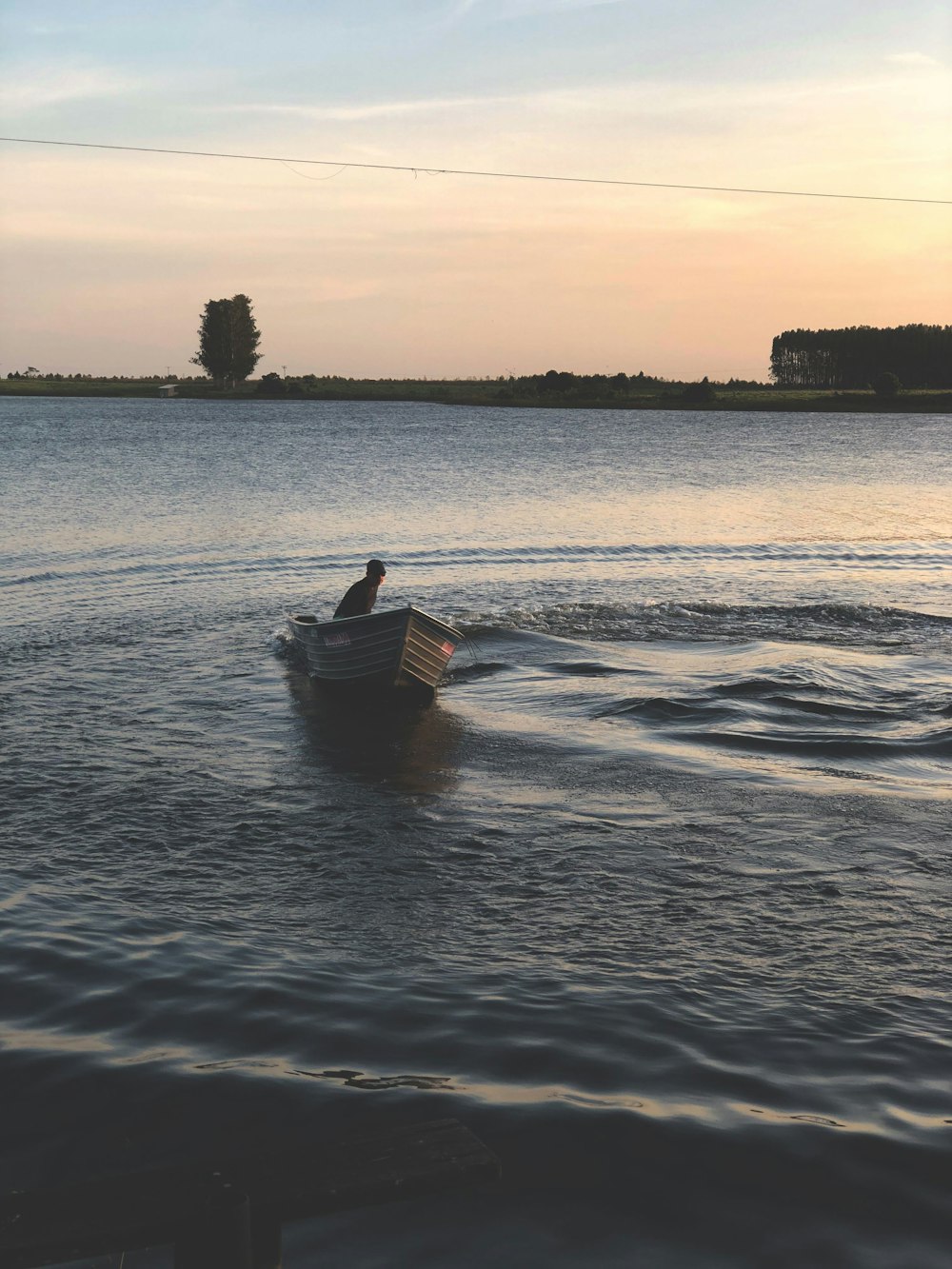 person on boat on calm body of water