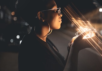 woman standing and holding string lights