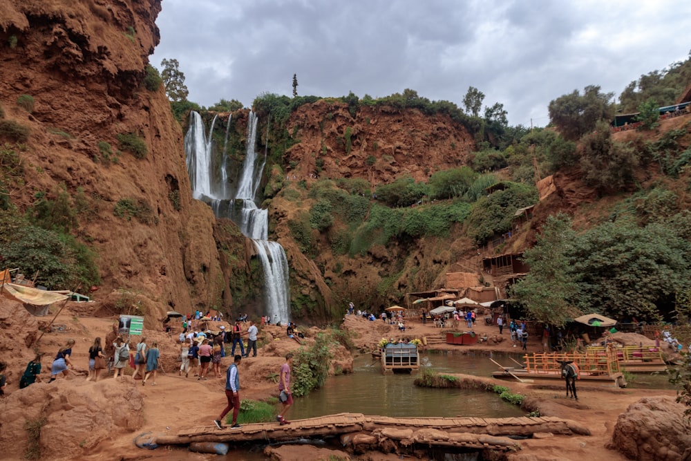 people walking and standing near waterfalls