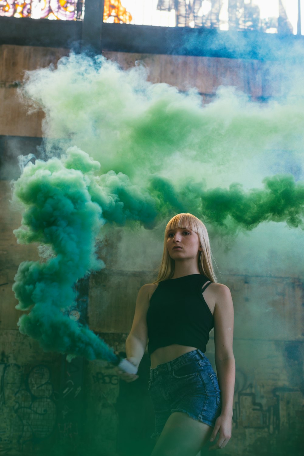 mujer sosteniendo un contenedor de humo verde
