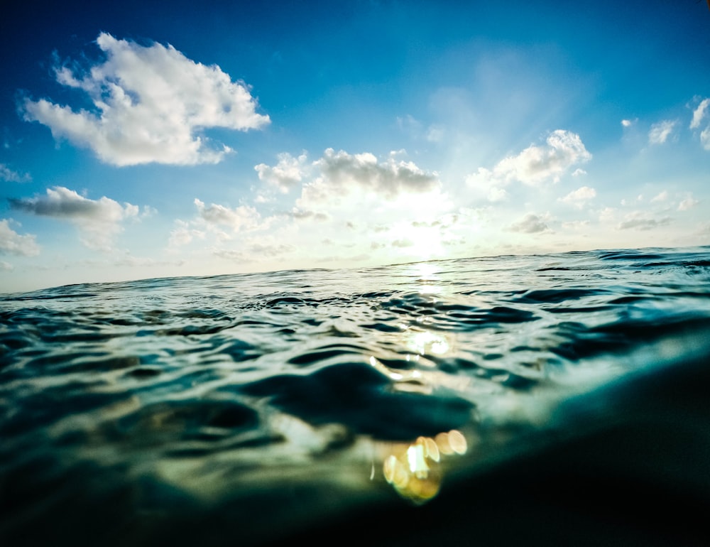 white clouds in blue sky over calm sea