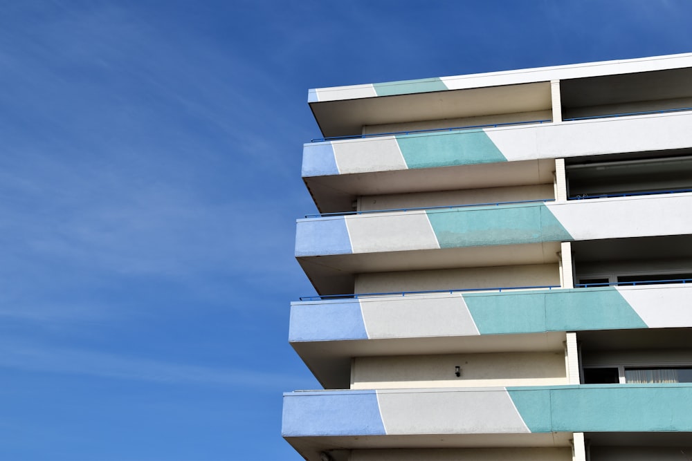 Un alto edificio blanco y azul con balcones