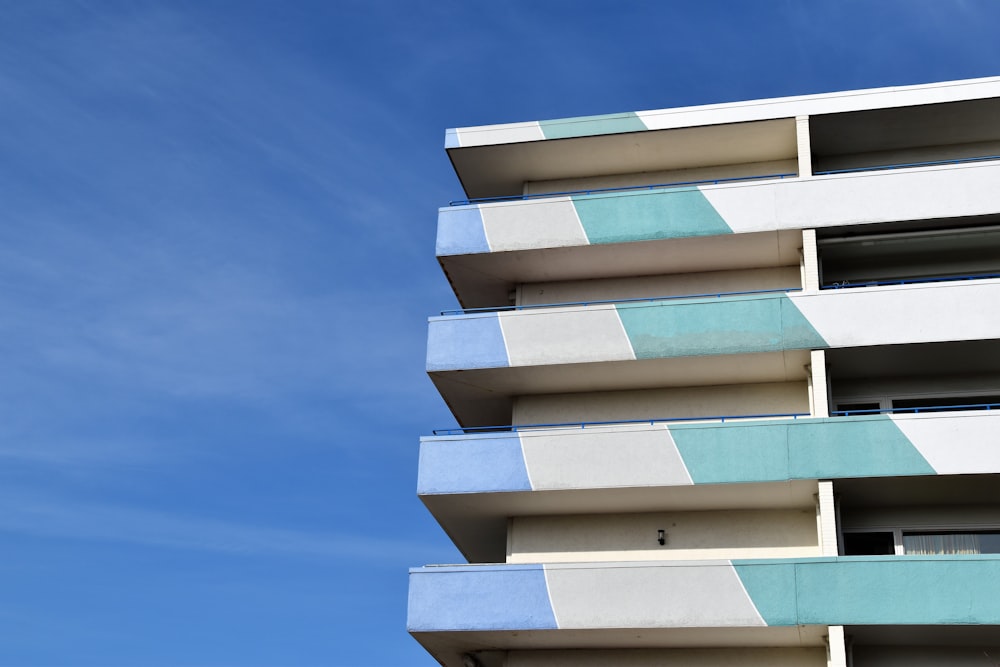 a tall white and blue building with balconies