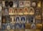 A detailed collection of vintage pins and badges displayed on a board. Each piece features intricate designs and inscriptions, many of which depict buildings and towers. The colors used are primarily gold, red, blue, and silver, giving the collection a historical and regal appearance.