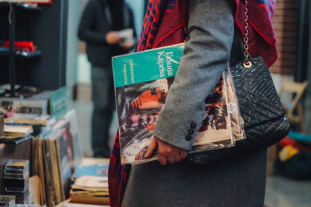 woman carrying assorted-title magazines