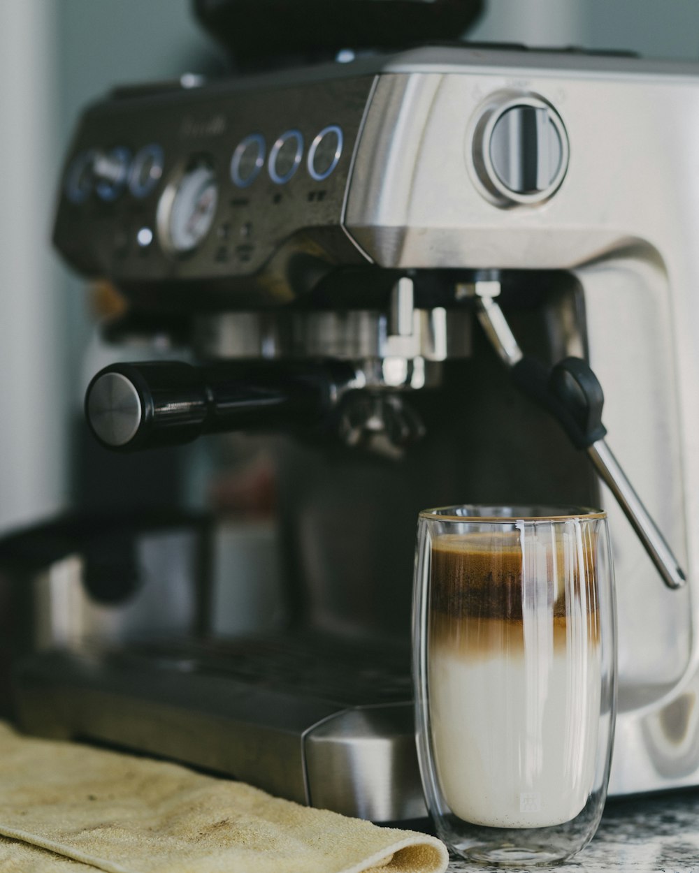 clear glass with beverage beside coffeemaker