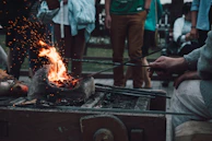 A blacksmith carefully twisting heated steel rods over a forge fire.
