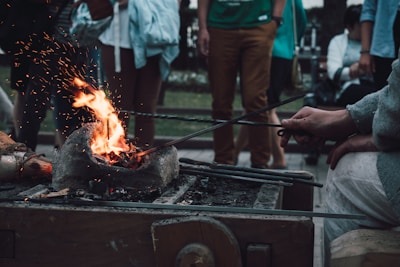A skilled artisan heating steel over a traditional forge, sparks flying around.