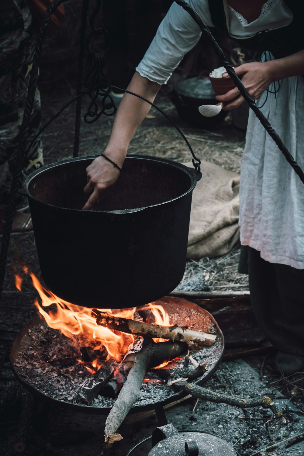 검은 금속 요리 냄비에 요리하는 여자