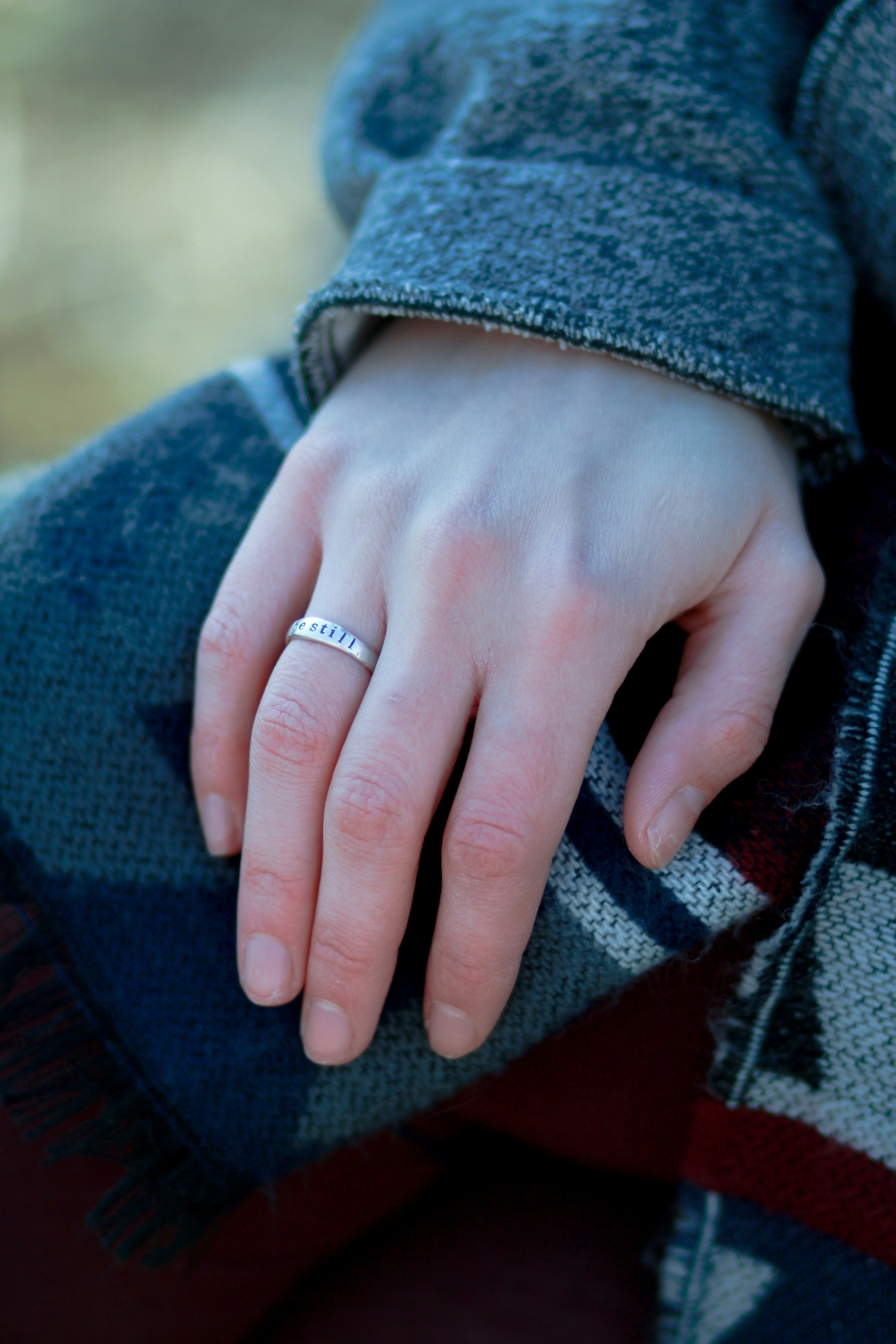 person wearing silver-colored ring